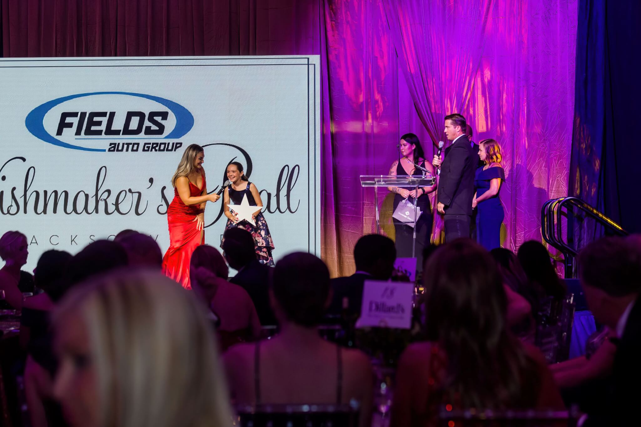 Adult hosts and Wish Kid on stage at the Wishmaker's Ball Jacksonville