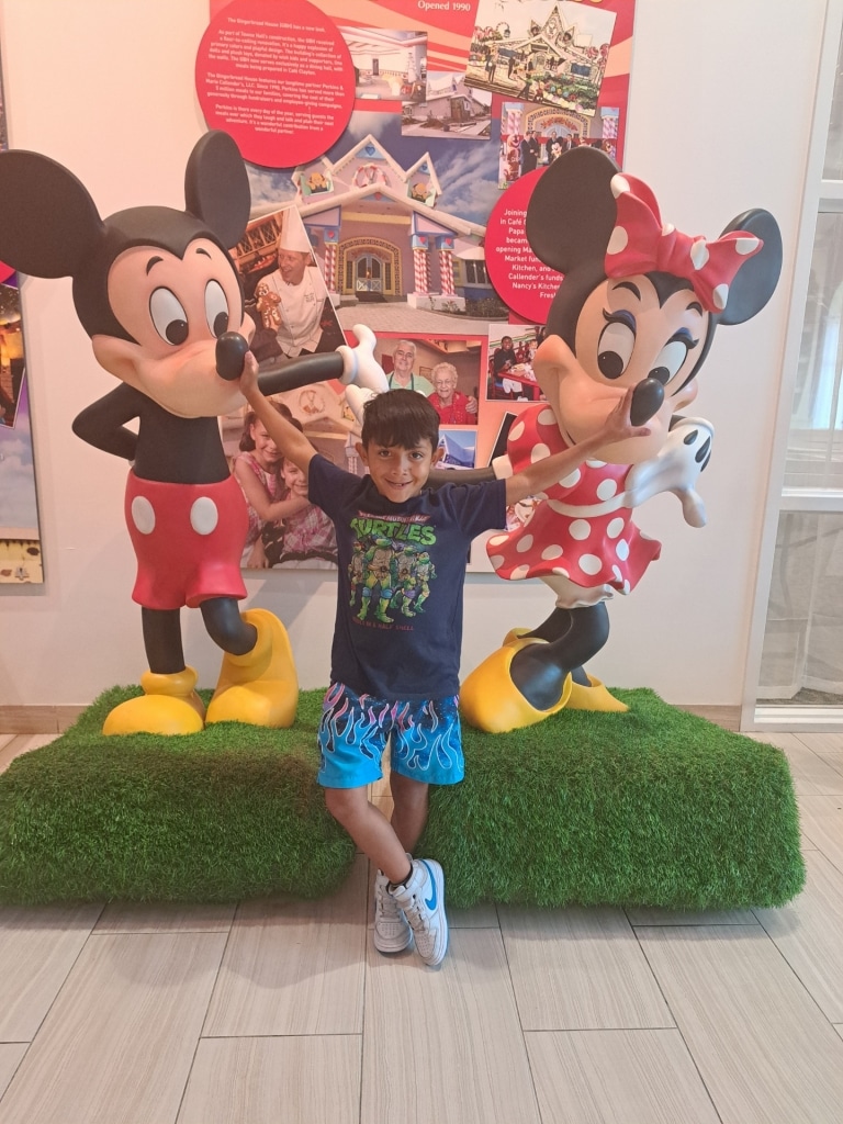 Wish Kid Harlem posing in front of Mickey and Minnie statues